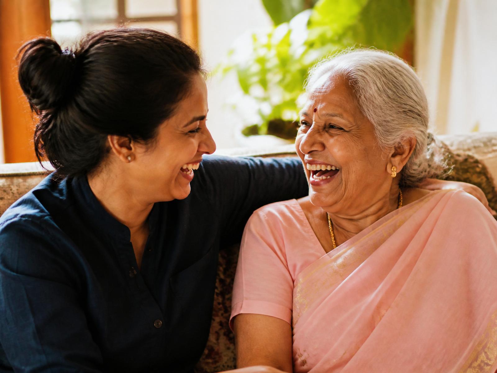 A companion laughing with an elderly woman at home